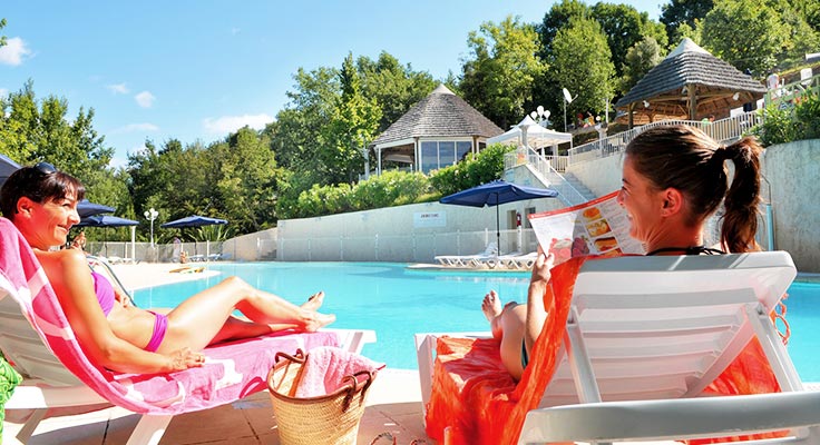 vacancieres bronzant sur un transat au bord de la piscine